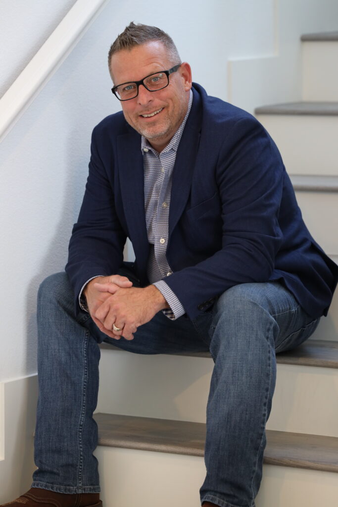 Vegas Home Lending mortgage professional sitting on staircase smiling